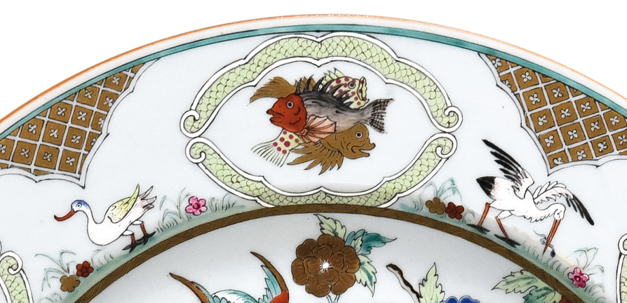 圖為清中期廣彩人物紋大碟細節(jié)圖，碟沿對稱開六窗繪魚紋，間繪六組鳥禽紋。（來源：廣州十三行博物館）
